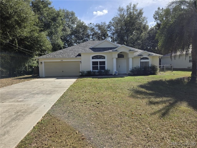 single story home with a garage and a front lawn