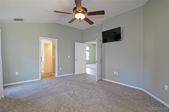 unfurnished bedroom with ceiling fan, light colored carpet, and vaulted ceiling