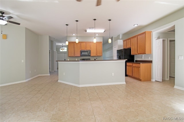 kitchen featuring ceiling fan, hanging light fixtures, light tile patterned floors, black refrigerator, and a kitchen island