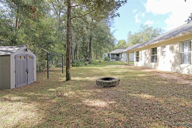 view of yard with a shed and an outdoor fire pit