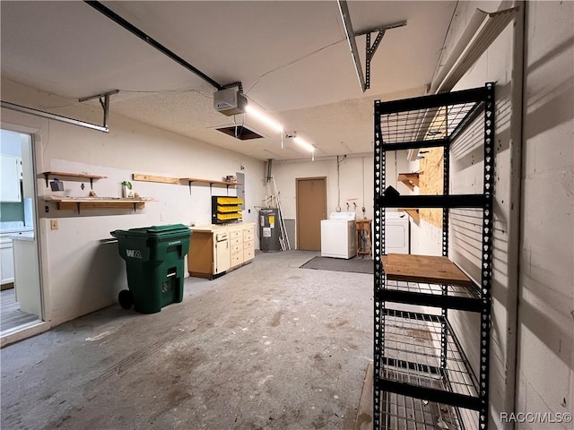 garage with washing machine and dryer, a garage door opener, and water heater