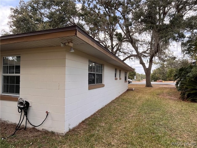 view of side of home with a yard