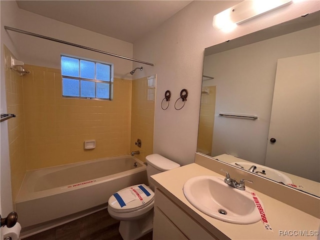 full bathroom with vanity, wood-type flooring, tiled shower / bath combo, and toilet