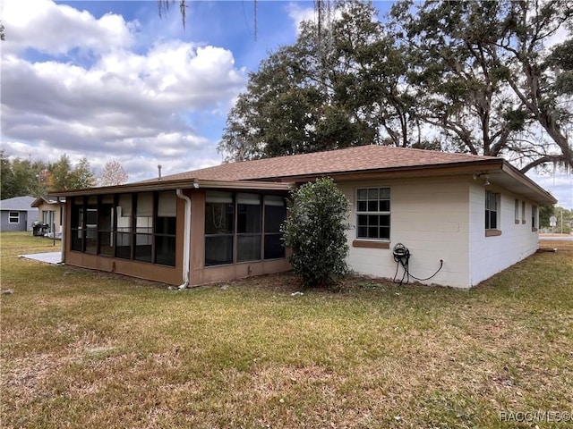 back of house with a sunroom and a yard