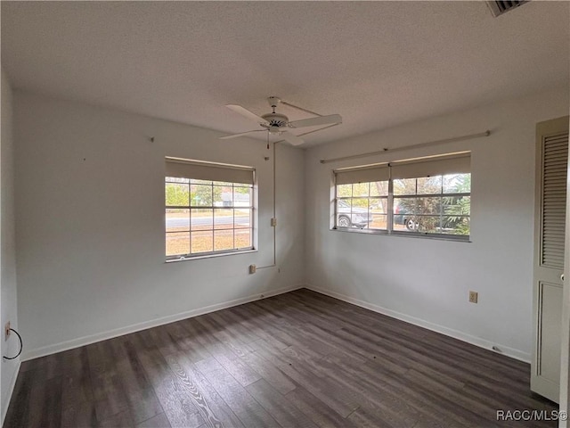 empty room featuring dark hardwood / wood-style floors, ceiling fan, and a textured ceiling