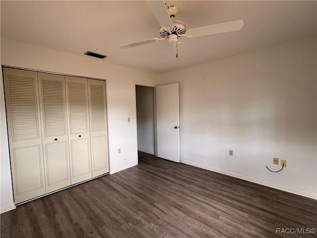 unfurnished bedroom with ceiling fan, dark hardwood / wood-style flooring, and a closet