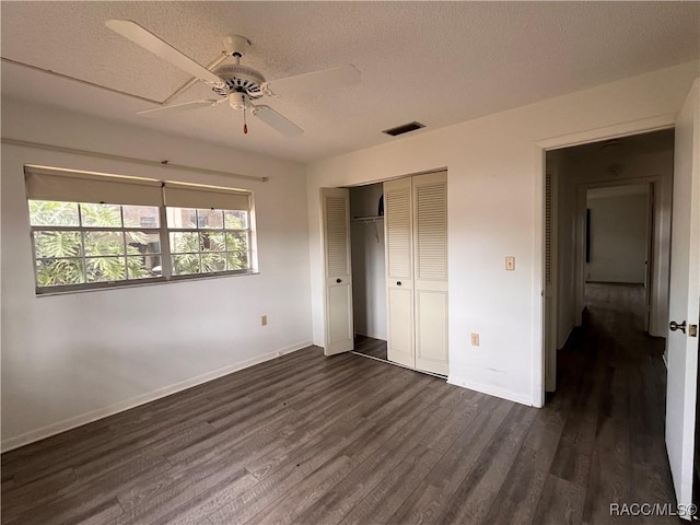 unfurnished bedroom with ceiling fan, dark hardwood / wood-style floors, a textured ceiling, and a closet