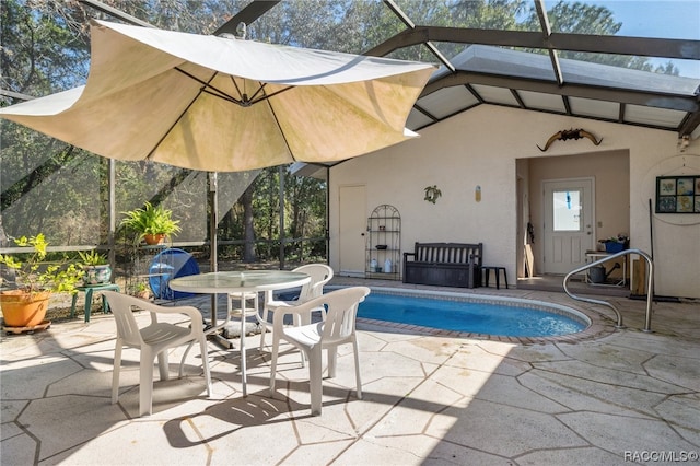 view of pool featuring glass enclosure and a patio