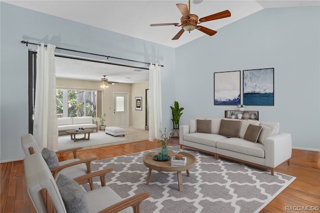 living room featuring wood-type flooring, ceiling fan, and lofted ceiling