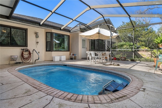 view of pool featuring glass enclosure and a patio