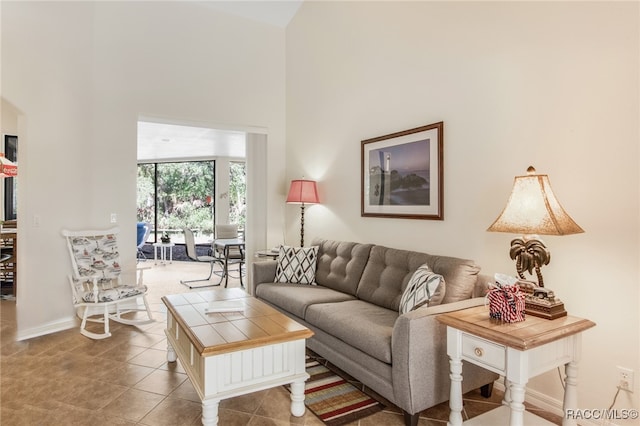 tiled living room featuring a high ceiling