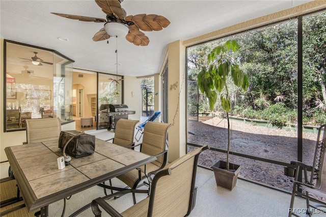 sunroom / solarium featuring ceiling fan