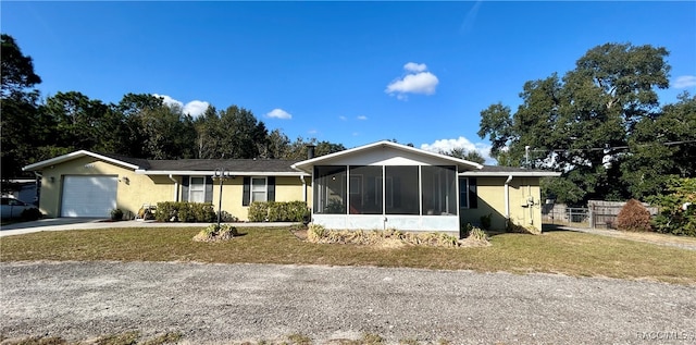 single story home with a front yard, a garage, and a sunroom