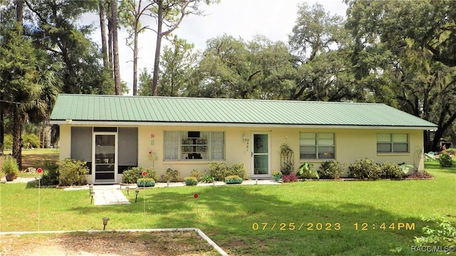 9461 W Tall Pines Ct, Crystal River, FL 34428 - single story home with stucco siding, a front lawn, and a metal roof