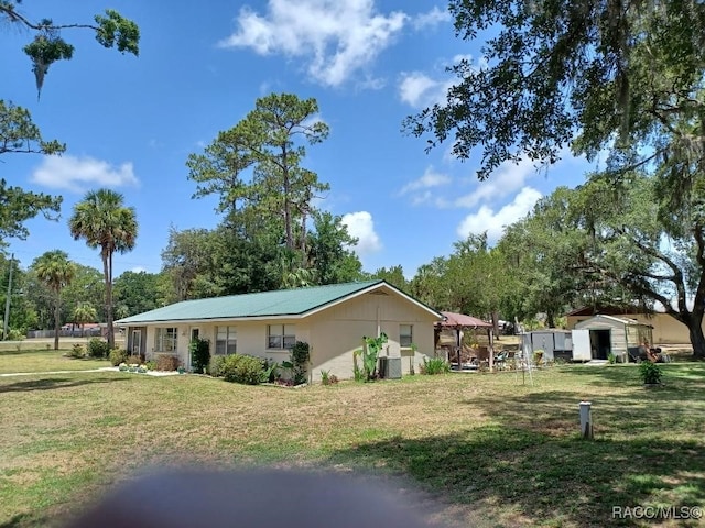 9461 W Tall Pines Ct, Crystal River, FL 34428 - view of property exterior with a lawn and a metal roof