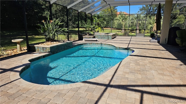 view of pool with a patio area, glass enclosure, and a hot tub