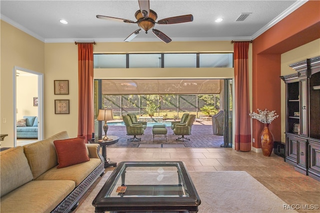 living room featuring ceiling fan, a textured ceiling, and ornamental molding