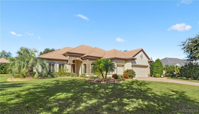 mediterranean / spanish-style house with a garage and a front lawn