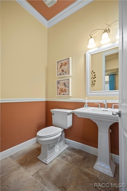 bathroom with ornamental molding and toilet