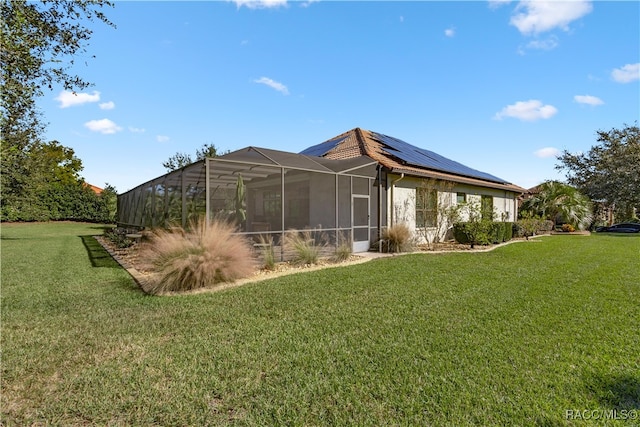 back of property featuring a lawn, solar panels, and a lanai