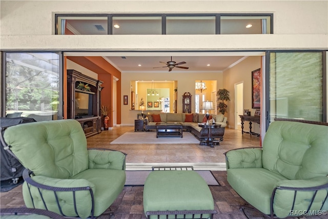 living room featuring ceiling fan with notable chandelier, dark wood-type flooring, and ornamental molding