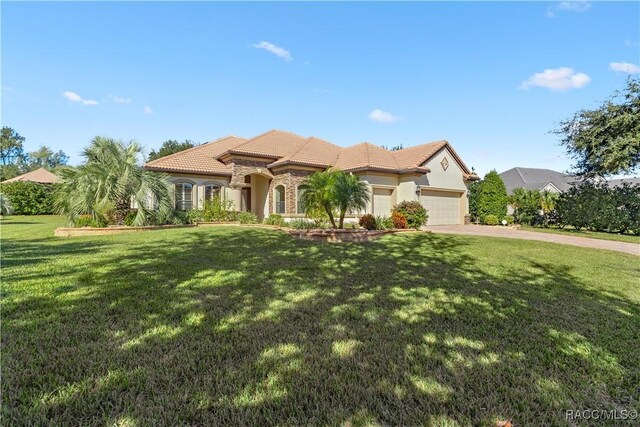 mediterranean / spanish-style home featuring a garage and a front yard