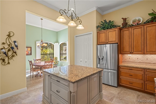 kitchen with light stone counters, ornamental molding, decorative light fixtures, a notable chandelier, and stainless steel fridge with ice dispenser