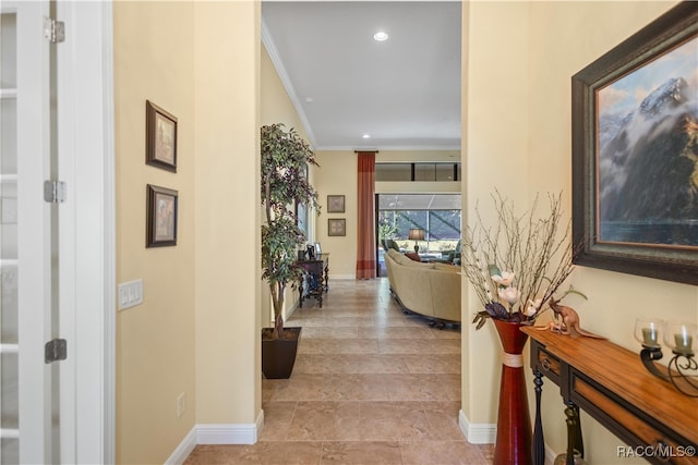 hall with light hardwood / wood-style floors and ornamental molding