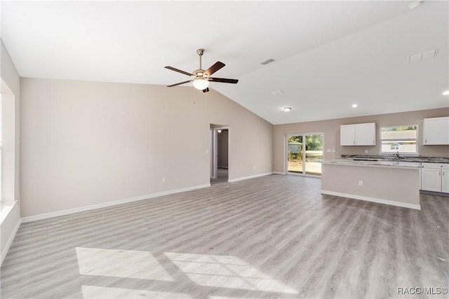 unfurnished living room featuring ceiling fan, lofted ceiling, and light hardwood / wood-style flooring