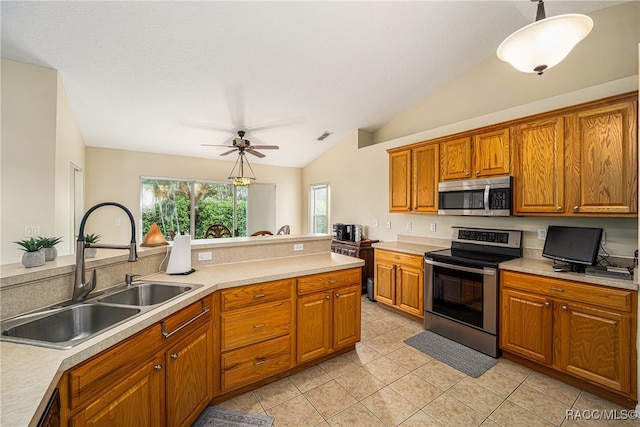 kitchen with lofted ceiling, sink, hanging light fixtures, ceiling fan, and appliances with stainless steel finishes