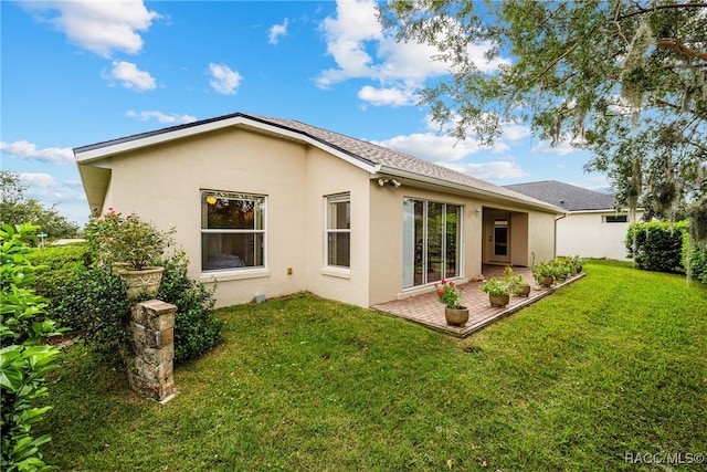 rear view of property featuring a patio area and a lawn