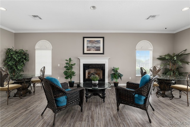 living area featuring light hardwood / wood-style floors and ornamental molding