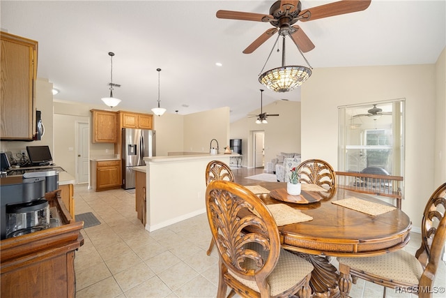 dining space with light tile patterned floors, lofted ceiling, and sink