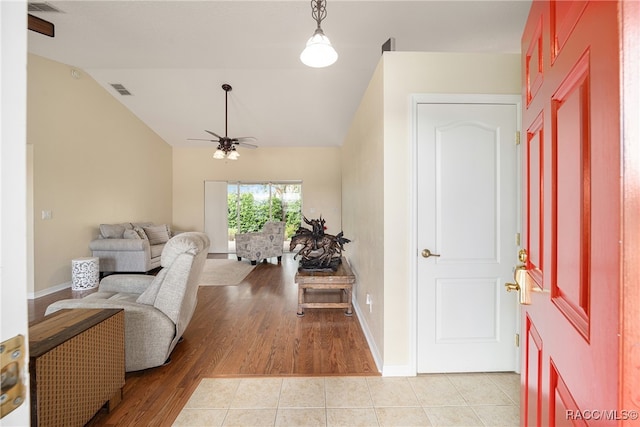 entryway with ceiling fan, light hardwood / wood-style flooring, and vaulted ceiling