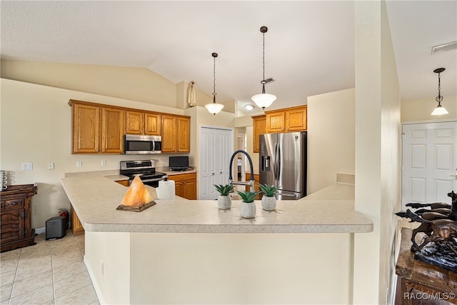 kitchen with pendant lighting, vaulted ceiling, appliances with stainless steel finishes, light tile patterned flooring, and kitchen peninsula