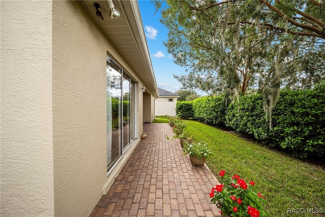 view of side of home with a yard and a patio