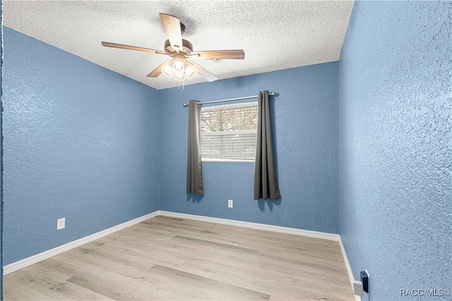 empty room featuring a textured ceiling, light hardwood / wood-style flooring, and ceiling fan