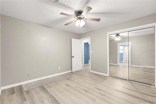 unfurnished bedroom with ceiling fan, a closet, a textured ceiling, and light hardwood / wood-style flooring