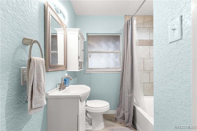 full bathroom featuring hardwood / wood-style floors, a textured ceiling, toilet, shower / bath combo with shower curtain, and vanity