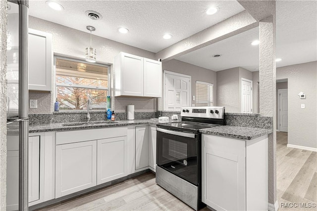 kitchen with sink, light wood-type flooring, a textured ceiling, appliances with stainless steel finishes, and white cabinetry