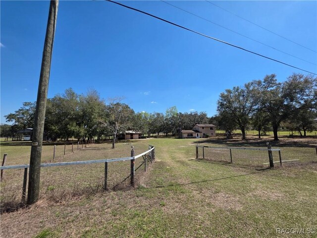 view of yard featuring fence and a rural view