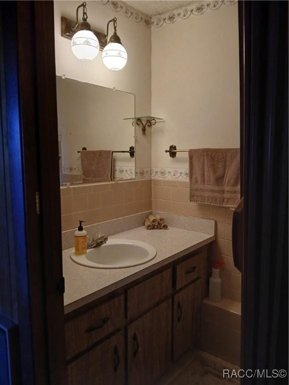 bathroom with wainscoting, vanity, and tile walls