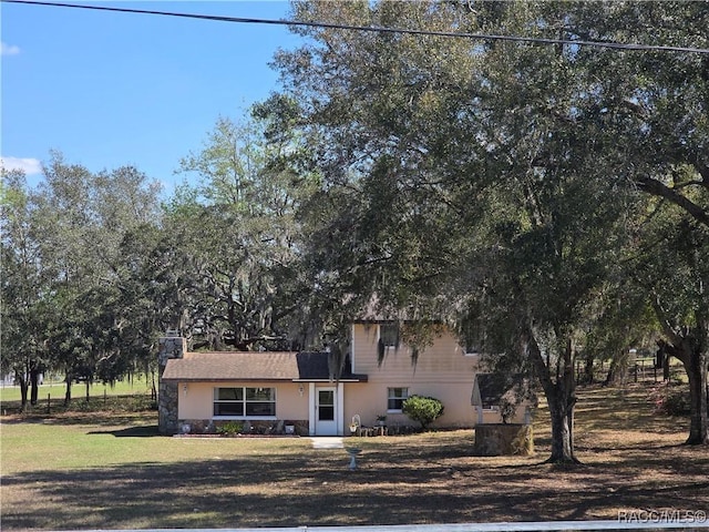 view of front of home featuring a front yard and stucco siding