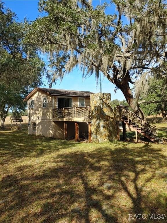 back of house with a yard and stairs