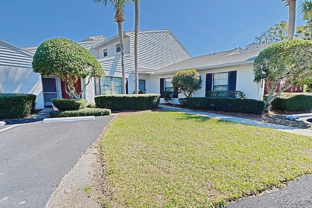 view of front facade with a front yard and stucco siding