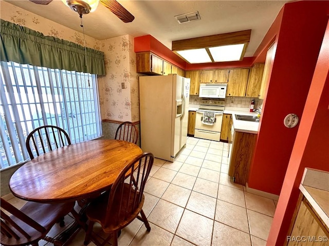 dining area featuring light tile patterned floors, visible vents, wallpapered walls, and ceiling fan