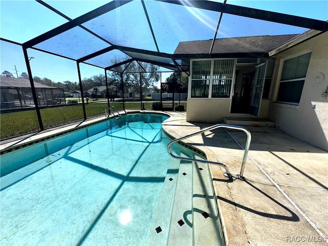 outdoor pool featuring glass enclosure and a patio