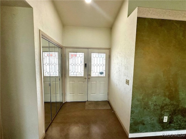 doorway featuring french doors, baseboards, and a textured wall