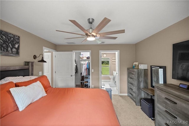 bedroom featuring carpet flooring, ensuite bathroom, ceiling fan, a spacious closet, and a closet