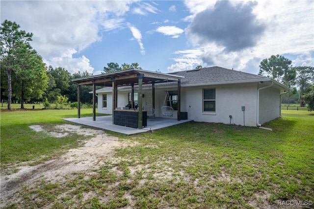 rear view of property with a yard and a patio area